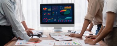 Analist ekibi, FBI Fintech 'i kullanarak mali konsolu inceliyor ve işaret ediyor. İş adamları iş görüşü için raporları inceliyor. Panorama çekimi. İnceleyin