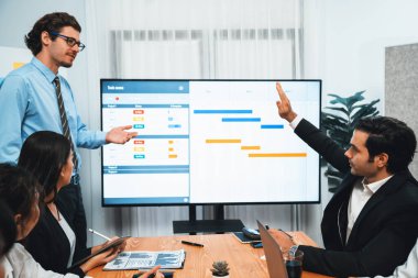 Proje yöneticisi toplantı odasında iş programları, Gantt program programı TV ekranında. Çoklu etnik çeşitlilik iş adamları ve modern iş projesi yönetimi. Habiliment