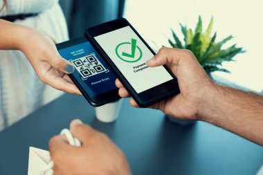 Parasız ödeme taraması için QR kodu ekranda görüntülendi. Kapalı eller, mobil uygulamadan elektronik işlem yoluyla para aktarmak için akıllı telefonu tutuyor. Hızlı ödeme için barkod teknolojisi. Coşkulu