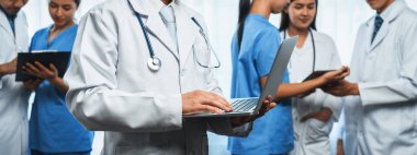 Hastanede dizüstü bilgisayar ve tabletle birlikte çalışan doktor hemşire ve sağlık uzmanlarına sahip tıbbi personel ekibi. Panoramik pankartta tıbbi işyeri ve sağlık hizmetleri topluluğu. Neoterik