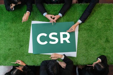 Yeşil çimen masasında panoramik CSR sembolü ve daha sürdürülebilir bir dünya için alternatif enerji kullanımını kurumsal sosyal sorumluluk olarak planlayan iş adamları. Antika