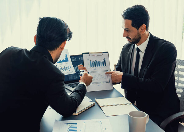 Занятая команда аналитиков обсуждает финансовые данные на цифровой приборной панели, анализирует диаграмму и график с помощью программного обеспечения для передачи данных на экране ноутбука. Бизнес-аналитика и Fintech. Пылкий
