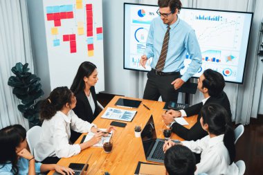 İş adamı, finansal rapor veri analizi veya pazar eğilimi gösterisiyle iş sunumunu şirketin gelecekteki yönetiminde stratejik planlama için büyük bir TV ekranında sundu. Habiliment