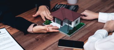 Temsilciyle ev kredisi sözleşmesini gözden geçiriyorum. Mali belgeleri ve vergi oranlarını, mülkiyet sahibi olmak için hesap makinesiyle analiz ediyorum. Yeni ev alımı ve finansman için anahtar imza. Coşkulu.