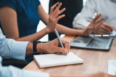 Sekreter, toplantı odasında görüşen bir grup çok ırklı iş adamıyla şirket toplantısında defterine not alıyor. Modern ofiste profesyonel toplantılarda çeşitlilik. Uyum
