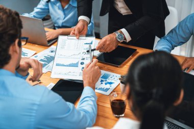 Ofis masasındaki finansal veri raporlarını analiz eden çeşitli bir grup iş analisti. Stratejik pazarlama planlaması için iş istihbarat analizine göre grafikler ve grafikler.