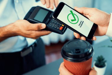 NFC QR kod cihazı ile el ele tutuşan akıllı telefon, hızlı dijital işlemler için temas kurulamayan ödeme kodlarını tarıyor. Modern yaşam tarzı ödeme teknolojisi için cep telefonundaki online bankacılık uygulaması. coşkulu