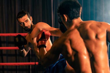 Asyalı ve Kafkasyalı Muay Thai boksörü vahşi boks maçında tekme sallıyor. Güçlü kaslı Taylandlı boksör acımasız dövüş hünerleriyle yumruk ve tekme tokuşturuyor. Impetus