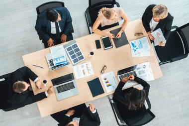 İş adamları grup toplantısı ofiste yukarıdan çekildi. İş kadınları, iş adamları ve ofis çalışanları toplantı masasında proje planlama belgeleriyle takım konferansında çalışıyorlar. Jivy
