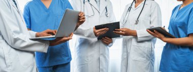 Hastanede dizüstü bilgisayar ve tabletle birlikte çalışan doktor hemşire ve sağlık uzmanlarına sahip tıbbi personel ekibi. Panoramik pankartta tıbbi işyeri ve sağlık hizmetleri topluluğu. Neoterik