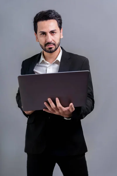 成功的商人穿着黑色西装 带着创新的科技理念 站着摆姿势 拿着笔记本电脑 带着兴奋的微笑面对着版权空间背景的促销或广告 — 图库照片