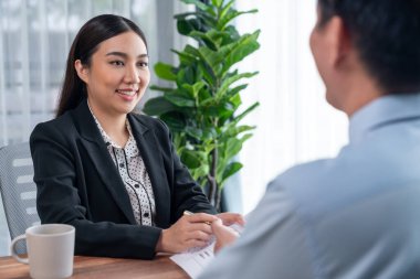 Görüşmeci ve aday arasındaki iş görüşmesi. İK müdürü aday niteliklerini ve özgeçmişli iş başvurusunu soruyor. Başvuru sahibinin işi. Sevinçli.