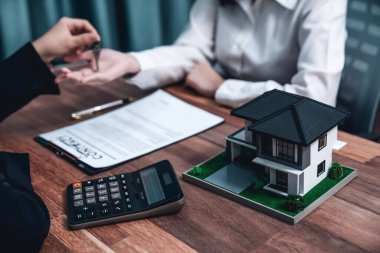 Bulanık emlakçı ev modeli ev kredisi anlaşmasının başarıyla tamamlanmasının ardından satın alma geçmişinin anahtarını bir sembol olarak teslim eder. Coşkulu.