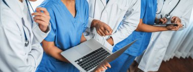 Hastanede dizüstü bilgisayar ve tabletle birlikte çalışan doktor hemşire ve sağlık uzmanlarına sahip tıbbi personel ekibi. Panoramik pankartta tıbbi işyeri ve sağlık hizmetleri topluluğu. Neoterik