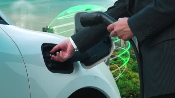 電気自動車による先進的なグリーンシティEsgシンボルの背景 ビジネスマンは 生態系と緑の記号で都市の充電ステーションで充電プラグとEv車のバッテリーを充電します — ストック動画