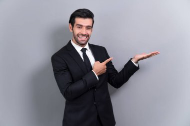 Resmi takım elbiseli kendine güvenen işadamı terfiyi ya da boş alanda reklamı işaret etmek için el ele tutuşuyor ve dışlanmış arka planda heyecanlı bir yüz ifadesi takınıyor. Coşkulu