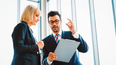 İki iş adamı toplantı odasında proje stratejisi hakkında konuşuyor. İş adamı, iş yerinde iş arkadaşlarıyla proje planlamasını tartışırken aynı zamanda mali raporla ilgili sohbet ve tavsiyelerde bulunuyor. Jivy