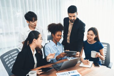 Mutlu iş adamları birlikte çalışır, şirket ofisinde tartışırlar. Profesyonel ve çeşitlilik takım çalışması iş planını bilgisayarda tartışır. Modern çok kültürlü ofis çalışanı. Uyum