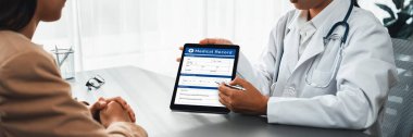Doktor, doktor kliniğinde genç hastalara destek olurken ve el ele tutuşurken tablet ve şefkat dolu sağlık hizmetleri danışmanlığı hakkında tıbbi teşhis raporu göster. Neoterik