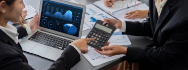 İş zekası ve veri analizi kavramı. Analizci ekibi laptop ekranında finansal veri analizi üzerinde çalışıyor. Etkili iş stratejik planlama için pazarlama göstergesi olarak. İçgörü