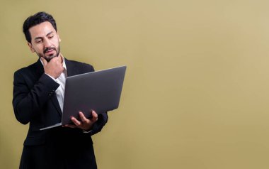 Yenilikçi teknoloji kavramına sahip başarılı bir iş adamı, ayakta duran, dizüstü bilgisayarı tutan ve telif alanı arka planında reklam ya da tanıtım için heyecanla gülümseyen. Coşkulu