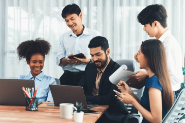 Mutlu iş adamları birlikte çalışır, şirket ofisinde tartışırlar. Profesyonel ve çeşitlilik takım çalışması iş planını bilgisayarda tartışır. Modern çok kültürlü ofis çalışanı. Uyum