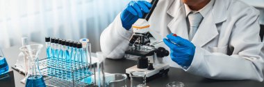 Bilim adamları yeni bir aşı ilacı ya da antibiyotik geliştirmek için mikroskop kullanarak tıbbi laboratuarda kimyasal deney yapıyorlar. Biyoteknoloji laboratuvarı ve tıp araştırma konsepti. Neoterik