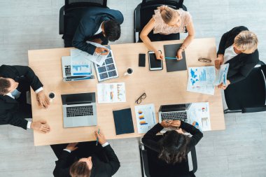 İş adamları grup toplantısı ofiste yukarıdan çekildi. İş kadınları, iş adamları ve ofis çalışanları toplantı masasında proje planlama belgeleriyle takım konferansında çalışıyorlar. Jivy