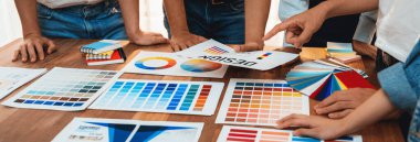 Grafik tasarımcı beyin fırtınası logosu ve grafik sanat yoğun yaratıcı stüdyo atölyesinde. Yaratıcı tasarım için çalışma masasında deney ve beyin fırtınası renk paleti ve desen. Panorama çekimi. İnceleyin