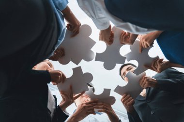 Çeşitli şirket çalışanlarının bakış açısının altında, yapboz parçalarını ortaklık ve takım çalışması konsepti olarak birleştirmek için ofiste işbirliği yapıyorlar. Yapboz 'u birleştirerek iş dünyasındaki birlik ve sinerji. Uyum