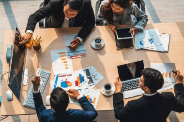 İş adamları grup toplantısı ofiste yukarıdan çekildi. İş kadınları, iş adamları ve ofis çalışanları toplantı masasında proje planlama belgeleriyle takım konferansında çalışıyorlar. Jivy