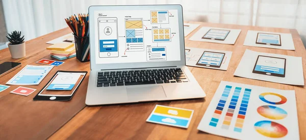 Dizüstü bilgisayar ekranında web ya da mobil uygulama UI UX için dijital ve kağıt kablo tasarımları. Beyin fırtınası ve tasarım uygulama çerçevesi için geliştirici çalışma alanının panoramik görüntüsü. İnceleyin