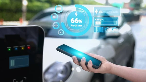 現代の実業家は Ev車が充電からエネルギーを充電しながら スマートフォンのモバイル3Dホログラムからバッテリーの状態を確認します 将来のEv自動車技術の革新的な技術進歩 Peruse — ストック写真