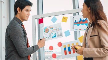 İş adamları ofisteki proje planlama kurulunda çalışıyor ve proje gelişimini analiz etmek için iş arkadaşlarıyla sohbet ediyorlar. Düzenli olması için cama yapıştırılmış yapışkan notlar kullanıyorlar. Jivy