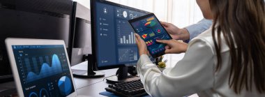 Analizci veri analizi ya da bilgisayar monitöründeki BI gösterge paneli üzerinde çalışıyor. Ticari pazarlama ve strateji planlaması için Fintech 'in şirket ofisindeki finansal verilerini analiz eden iş ekibi. Önde.