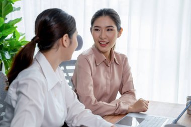 Modern ofis çalışma alanında iş birliği yapan iki genç ofis çalışanı, modern ofis çalışanı olarak profesyonelliklerini sergileyerek, dizüstü bilgisayarda tartışıyorlar ve birlikte çalışıyorlar. Coşkulu.