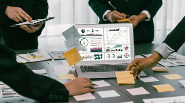 Analizci ekibi yaratıcı ve analitik beyin fırtınası fikri için bilgisayar ekranında BI veri paneli olan yapışkan bir not kullanıyor. Pazarlama stratejisi için finansal veri görselleştirme teknolojisini analiz et. Dahi.