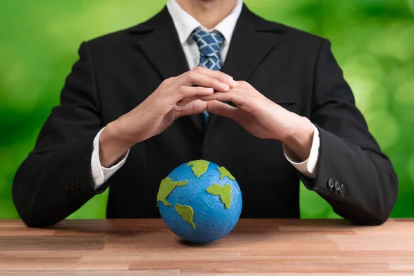 stock image Businessman holds paper earth as symbol of eco environmental awareness for sustainable world using clean energy and zero CO2 emission. Eco-friendly corporate with go green policy to save earth. Alter