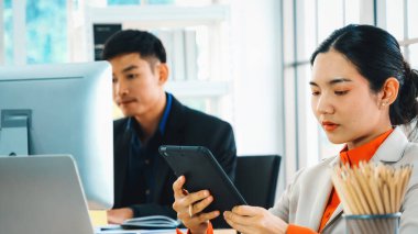 Modern ofis odasındaki masada çalışan iş adamları mali veri raporlarını incelerken. Jivy