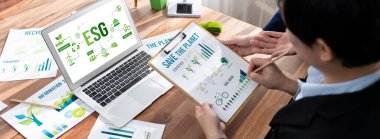 ESG 'nin çevresel sosyal yönetimi, çevre dostu şirket toplantılarında, temiz ve sürdürülebilir gelecekteki ekoloji için çevre korumasını uygulayan iş adamlarıyla dizüstü bilgisayarda sergileniyor. Önde.