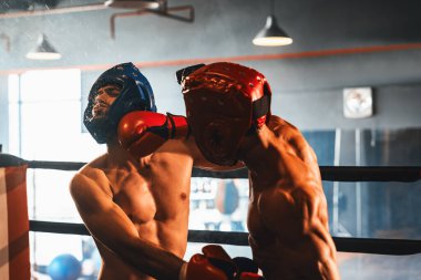 Kasklı iki atletik ve kaslı vücut boksörü ya da boks baş muhafızı vahşi bir boks maçında karşı karşıya. Boks dövüşçüsü boks ringinde dövüşüyor. Impetus