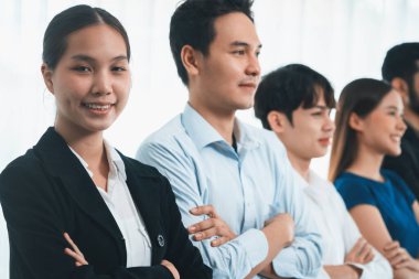 Profesyonel iş adamlarından oluşan çeşitli gruplar modern kurumsal ofiste çapraz kol hareketi ile sırada bekliyor. Mutlu ve gülümseyen, çok ırklı ofis çalışanı ekip birleşmesi ve birlikte başarılı. Uyum