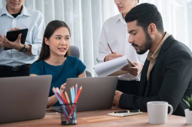Profesyonel Asyalı çalışanlar, şirket ofisinde takım olarak çalışarak iş planları ve bilgisayarla başarılı olmak için verileri tartışırlar. Modern ofis çalışanı takım çalışması konsepti. Uyum