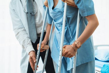 Doktor hastanede koltuk değnekli hastayla ilgileniyor. Fizyoterapist ve bacak yaralanması konsepti. Jivy