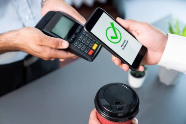 NFC QR kod cihazı ile el ele tutuşan akıllı telefon, hızlı dijital işlemler için temas kurulamayan ödeme kodlarını tarıyor. Modern yaşam tarzı ödeme teknolojisi için cep telefonundaki online bankacılık uygulaması. coşkulu
