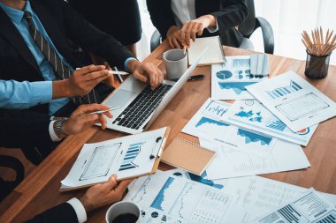 Ofis masasındaki finansal veri raporlarını analiz eden çeşitli bir grup iş analisti. Stratejik pazarlama planlaması için iş istihbarat analizine göre grafikler ve grafikler.