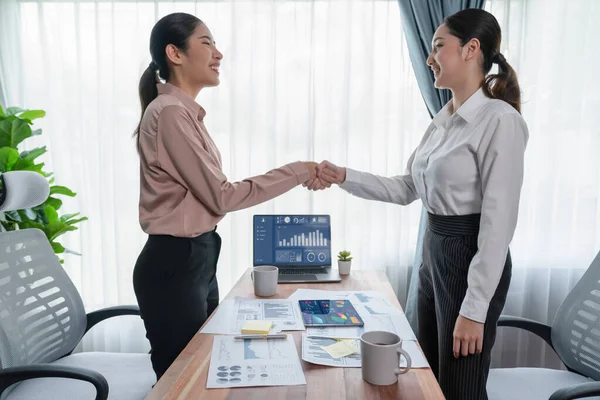 ダッシュボード データ ペーパーの山を分析し 職場の概念におけるチームワークと整合性の重要性として成功裏に分析した後 現代のオフィスで握手をする2人のアジアのビジネス女性 熱狂的 — ストック写真
