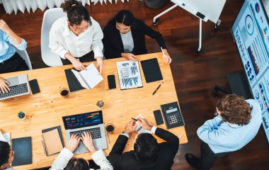 Toplantı masasındaki finansal veri raporlarını analiz eden çeşitli iş analist gruplarının geniş görüşü. İş zekası analizine göre çizelge ve grafik paneli. Çok titiz.