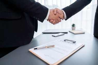 İki profesyonel, yakın el sıkışma ile iş anlaşmasını başarıyla tamamlayarak, ortaklık anlaşmasını imzaladı. Yasal belge ve el sıkışma iki şirket arasında resmi bir anlaşma. Coşkulu