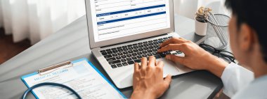 Doktor, laptoptaki tıbbi raporları dikkatle gözden geçir ve hastaların doktor muayenehanesinde etkili bir sağlık tedavisi için hastalık teşhisi koy. Profesyonel tıbbi değerlendirme. Neoterik
